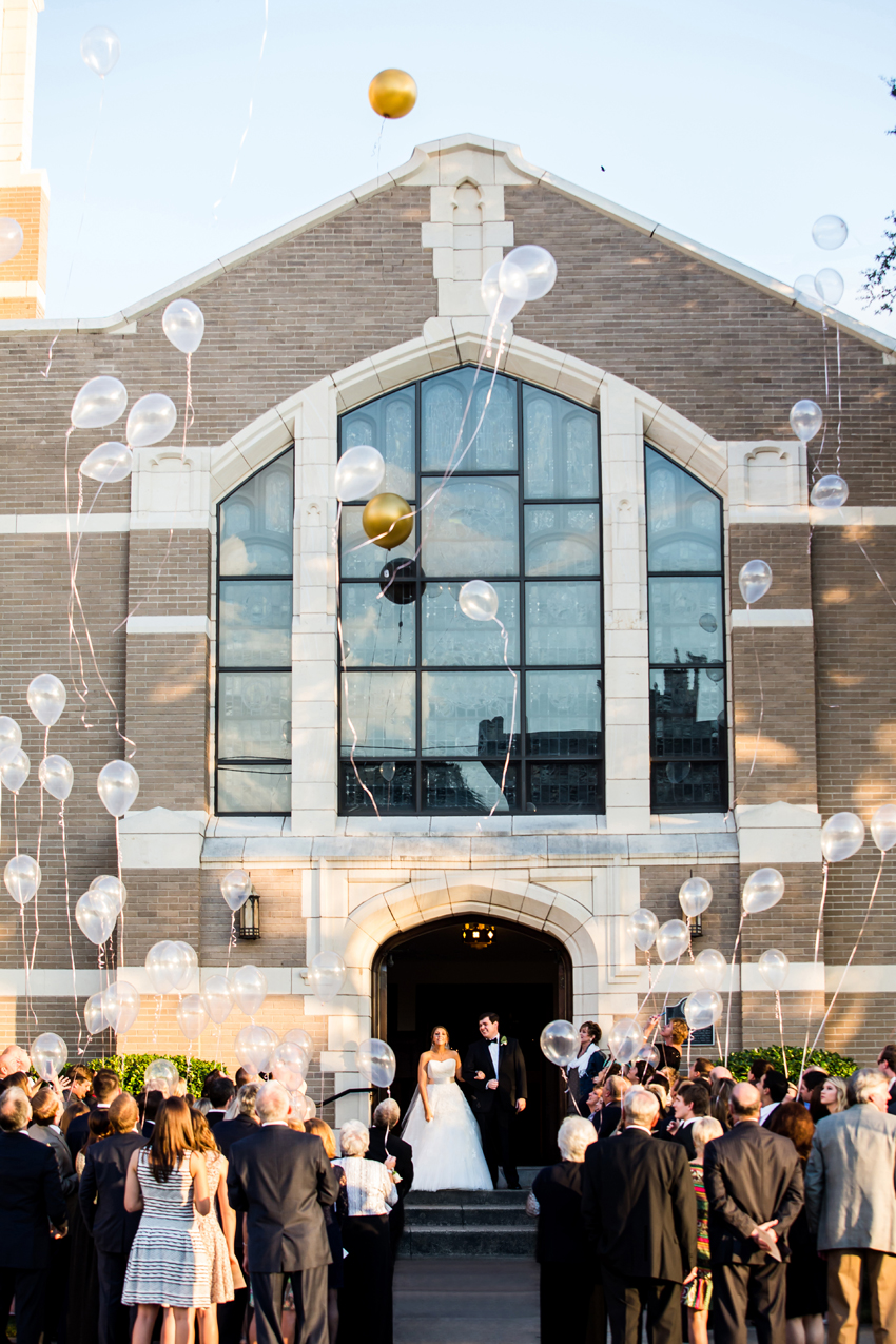 Balloons being released as bride and groom walk out of church.